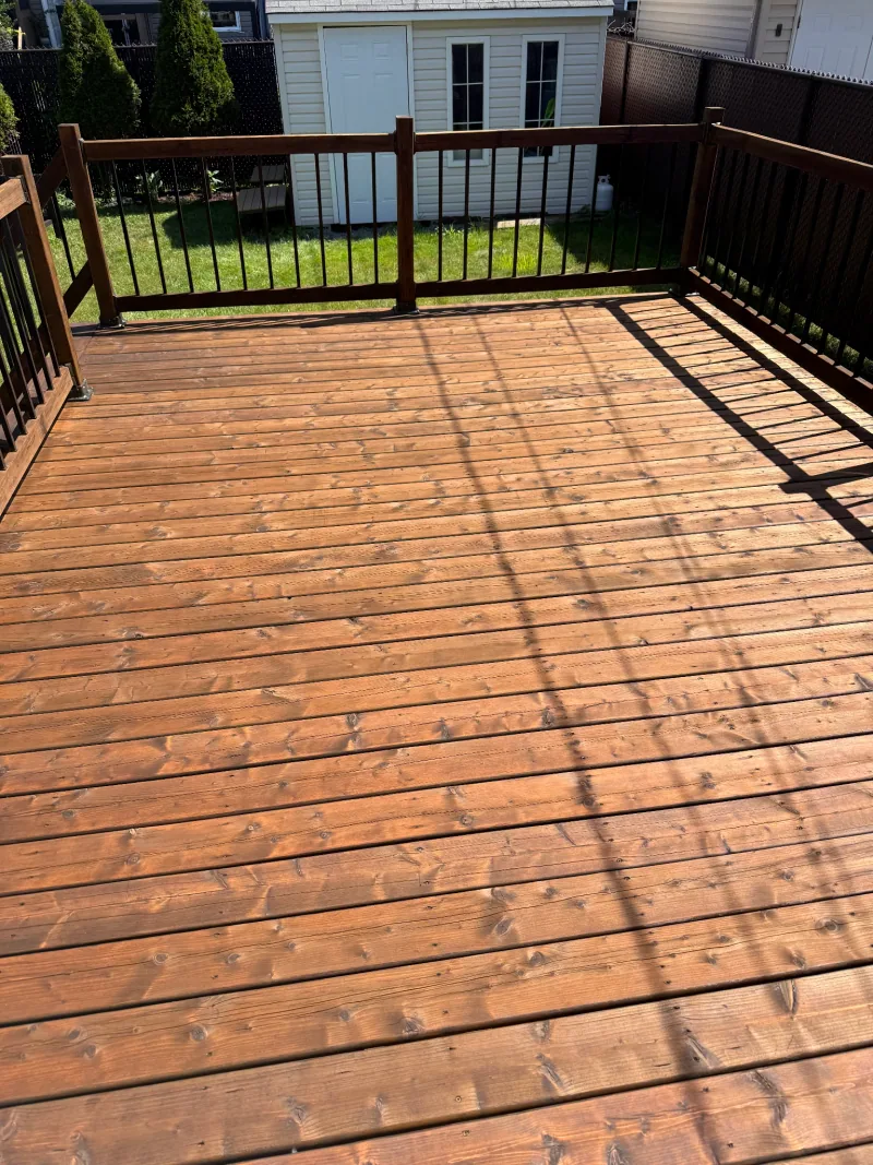 A finished wood deck with sunlight falling across the boards.
