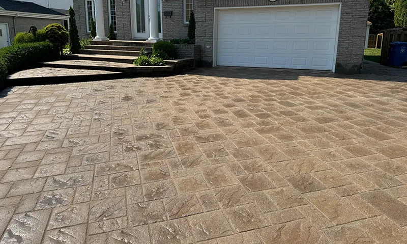 A paved driveway with sand joints in front of a home.